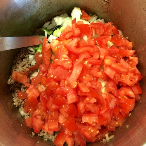 photo of chili mixture topped with diced tomatoes