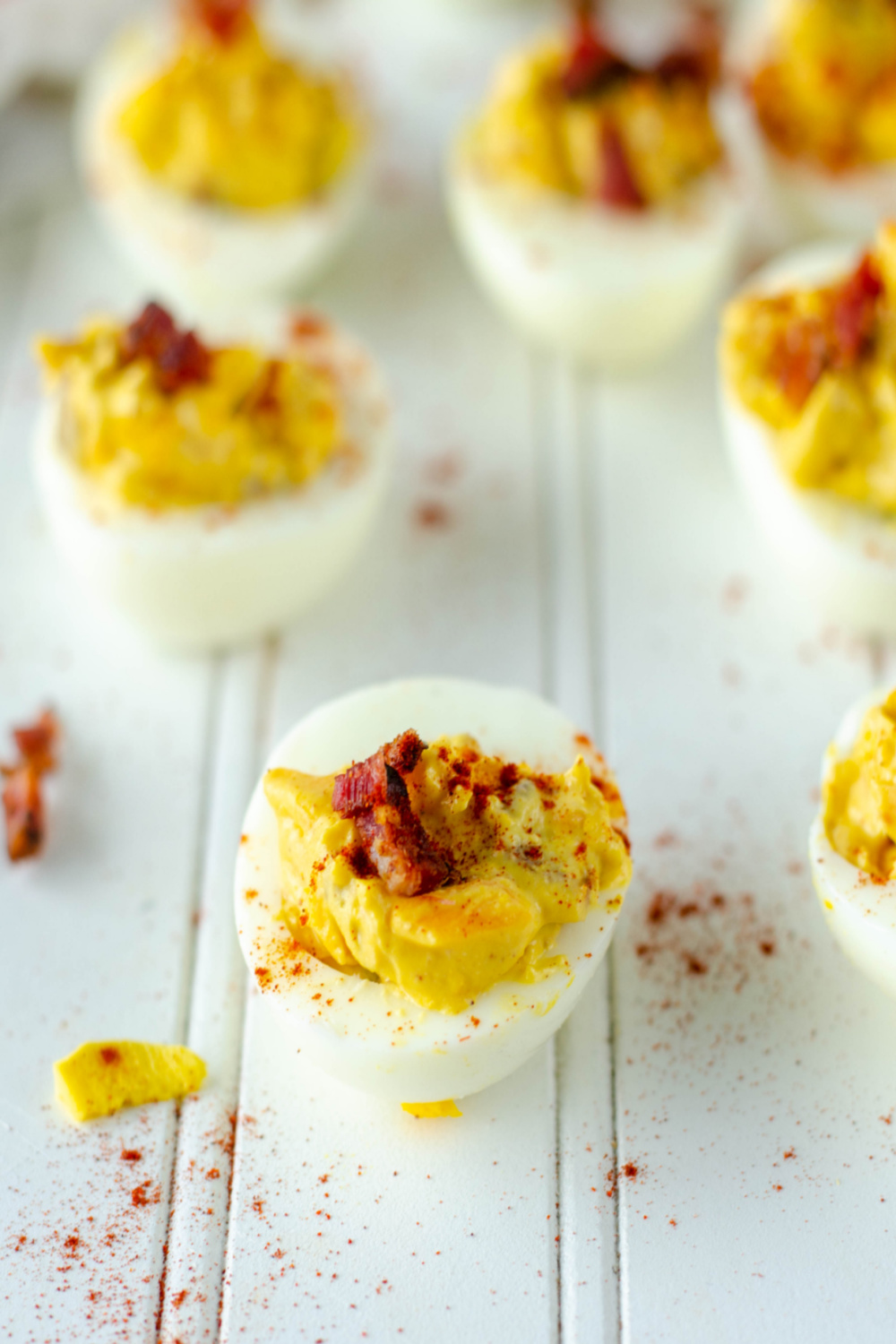 close up of a bacon cheddar deviled egg on a white board