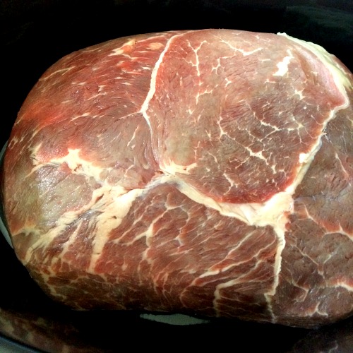 photo of uncooked roast beef in a black slow cooker