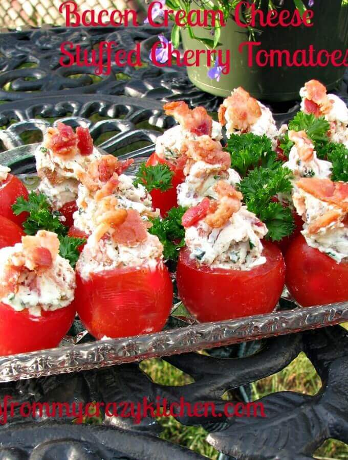 Photo of Bacon Cream Cheese Stuffed Cherry Tomatoes in a glass plate on a rod iron table