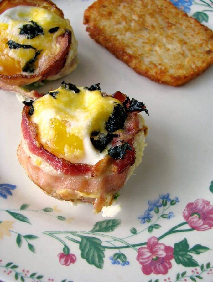 Sunny side up eggs in a bacon cup filled with diced jalapeno and shredded cheese, topped with more cheese and chopped basil, these Bacon Jalapeno Egg Cups are great for a weekend breakfast, or for a party brunch. 
