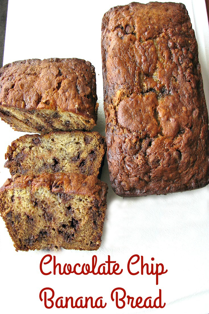 Overhead photo of two loaves of chocolate chip banana bread one whole one sliced on white cutting board
