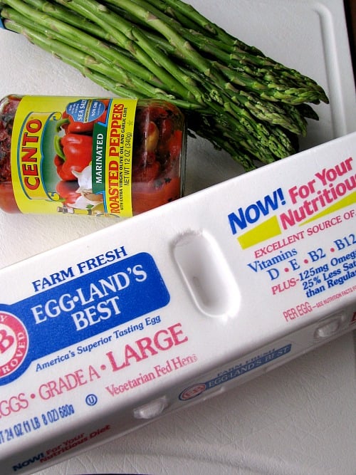 Photo of a jar of Cento brand roasted red peppers, a bunch of asparagus, and a carton of Eggland's Best Eggs