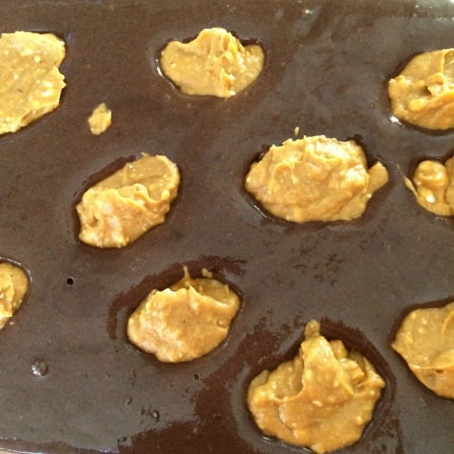 Photo of prepared cake mix topped with spoonfuls of pumpkin cream cheese mixture