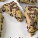 Photo of Peanut Butter Chocolate Chip Scones on a large white cutting board with a white napkin