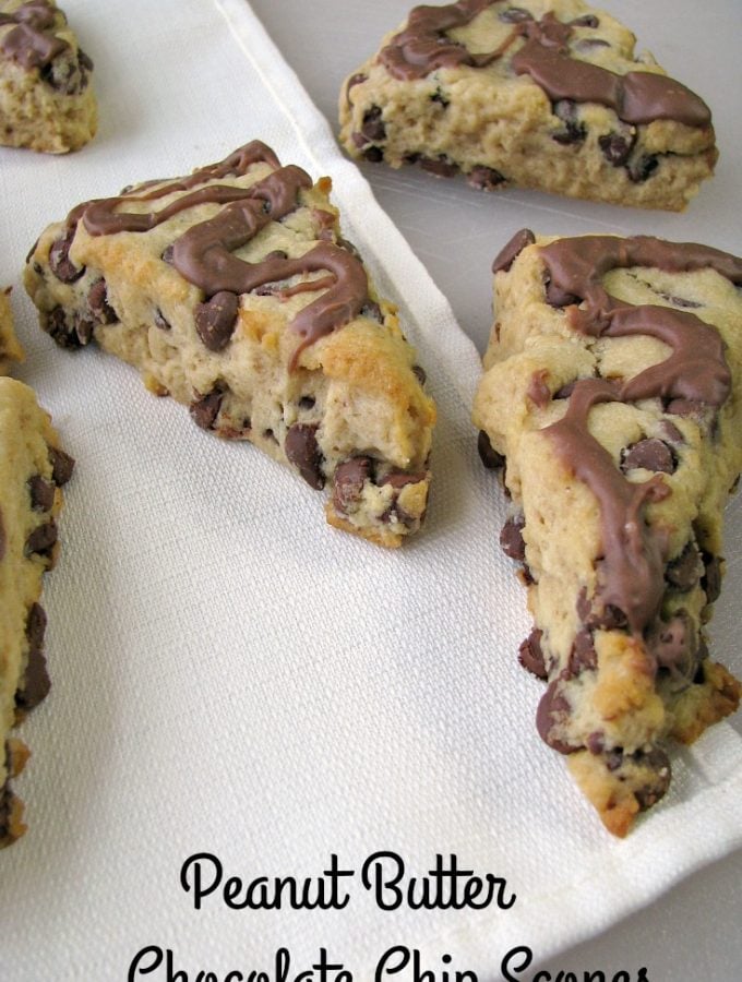 Photo of Peanut Butter Chocolate Chip Scones on a large white cutting board with a white napkin