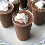 Close up photo of Chocolate Eggnog Pudding Shots on a white plate with flower trim