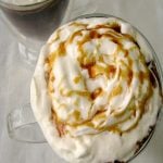 Photo of Salted Caramel Hot Chocolate in two glass mugs on a white tablecloth