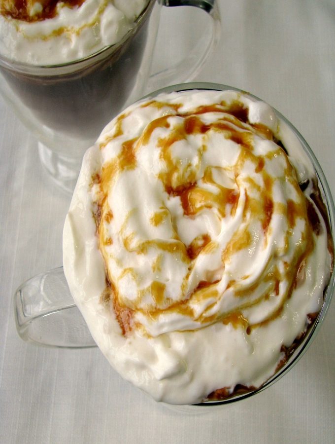 Photo of Salted Caramel Hot Chocolate in two glass mugs on a white tablecloth