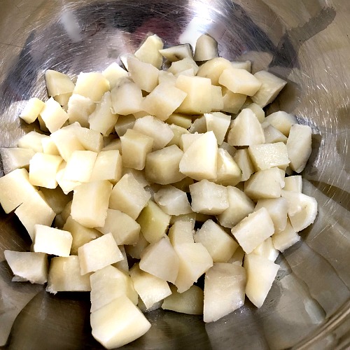 photo of cooked diced potatoes in a metal bowl