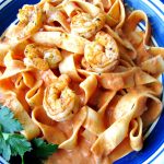 Close up photo of plated Cajun Shrimp Pasta on a blue rimmed plate