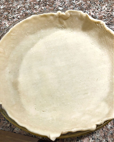 photo of an unbaked pie crust in a pan