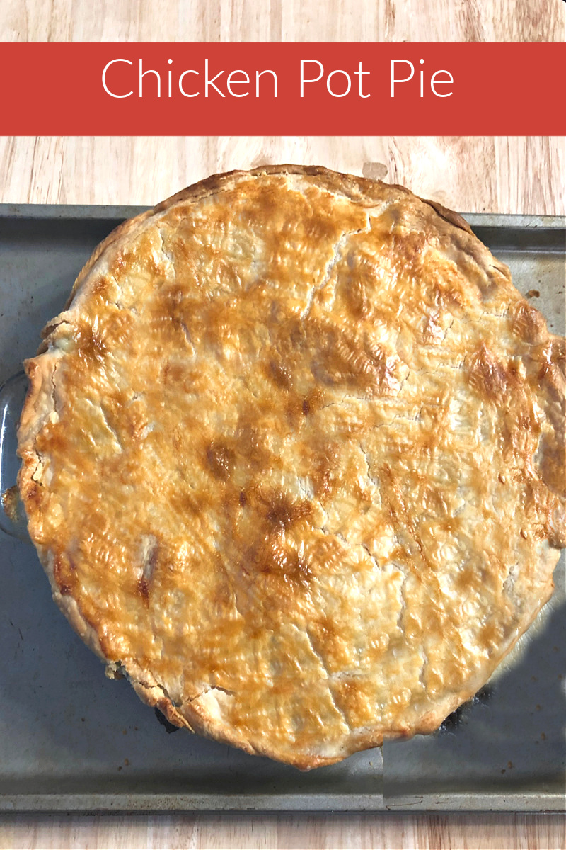 photo of a whole pot pie on a baking sheet on top of a wood table